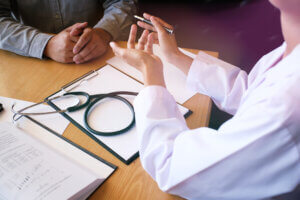 Clinician discussing care with a patient at a desk.