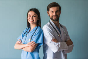Two physicians standing together in a clinical setting.