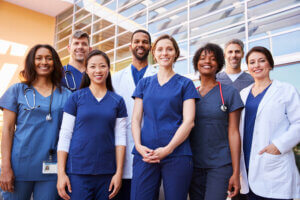 Diverse medical team standing outside a hospital.