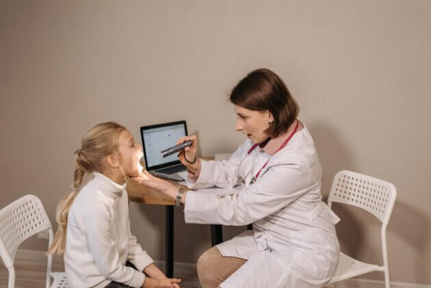 Pediatric clinician examining a child during a consultation.