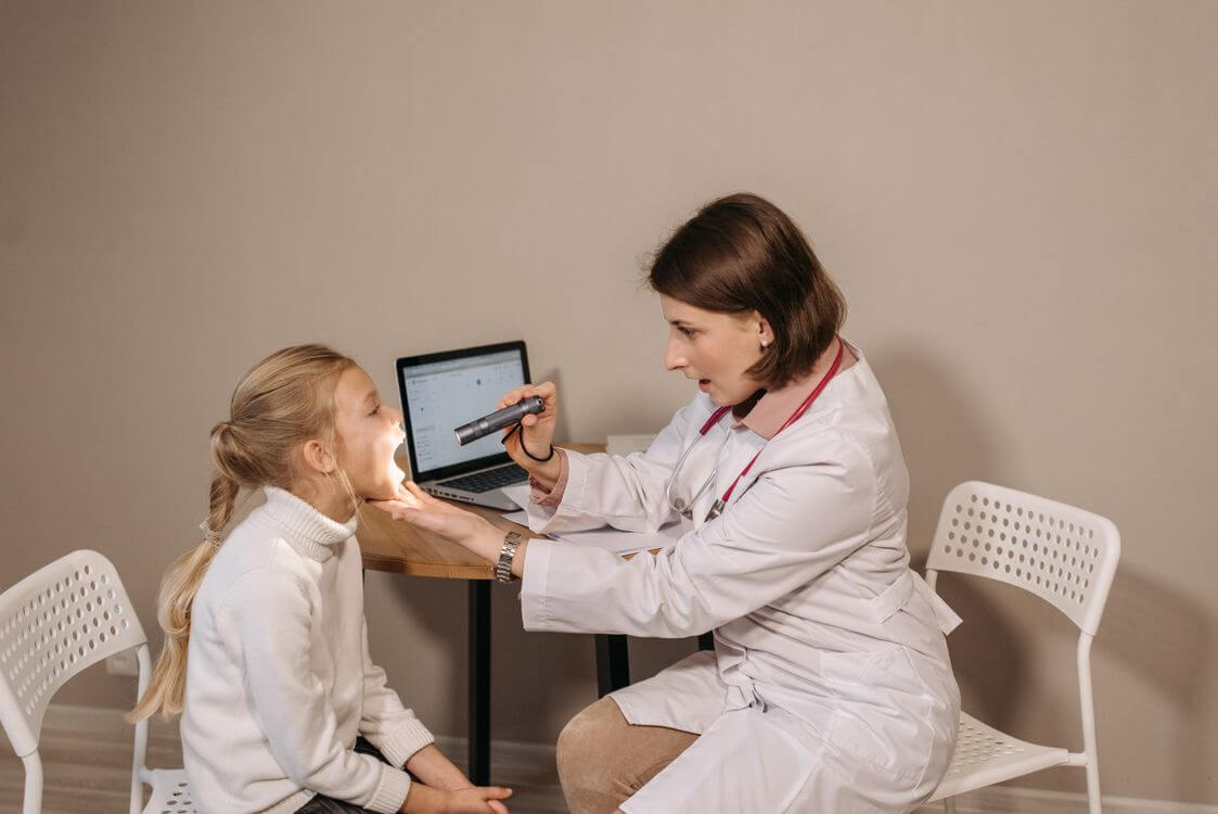 Pediatric clinician examining a child during a consultation.