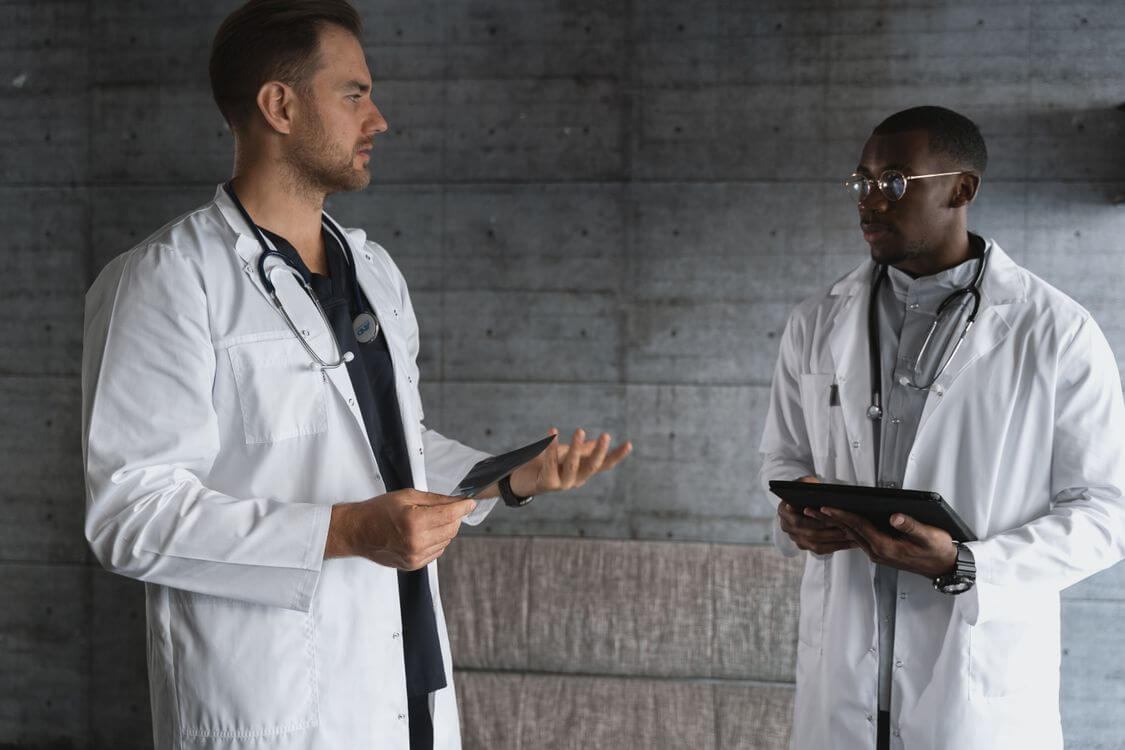 Two physicians discussing a case with a tablet.