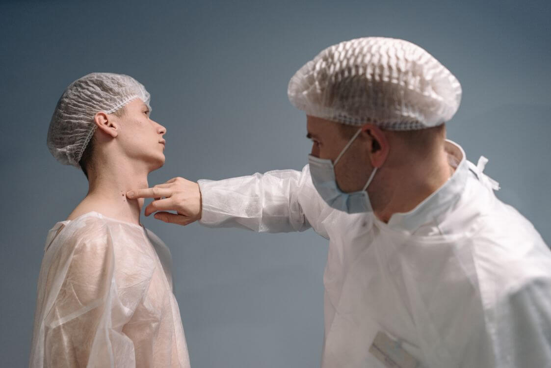 Clinician examining the skin on a patient’s neck.